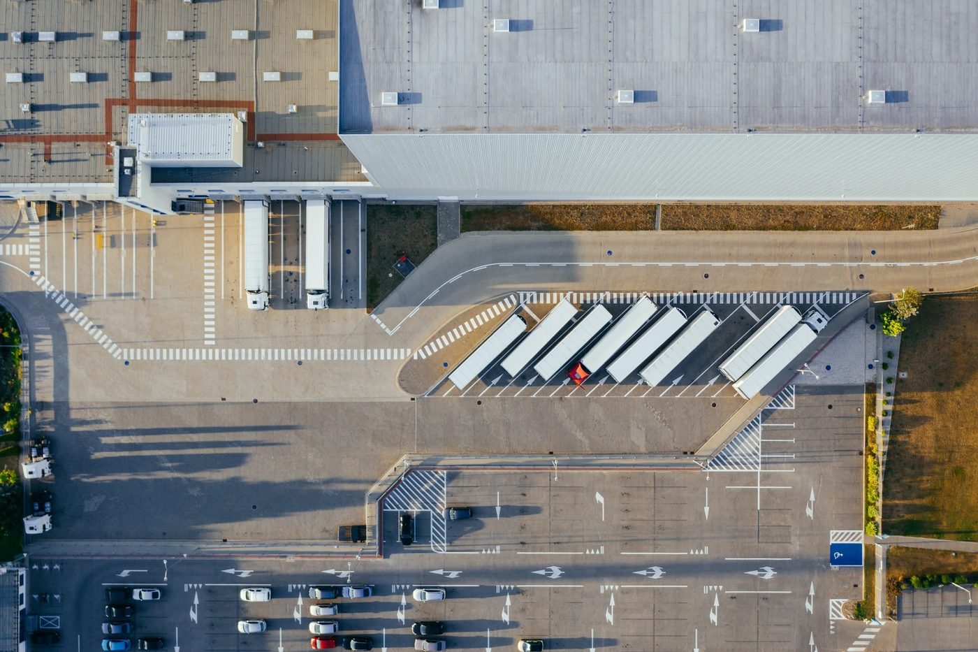 Overhead view of an industrial warehouse with several trailers parked.