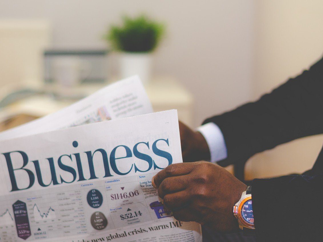 A man holding a Business newspaper.